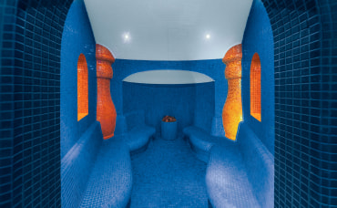 Wnętrze sauny parowej z niebieskimi kafelkami i podświetleniem